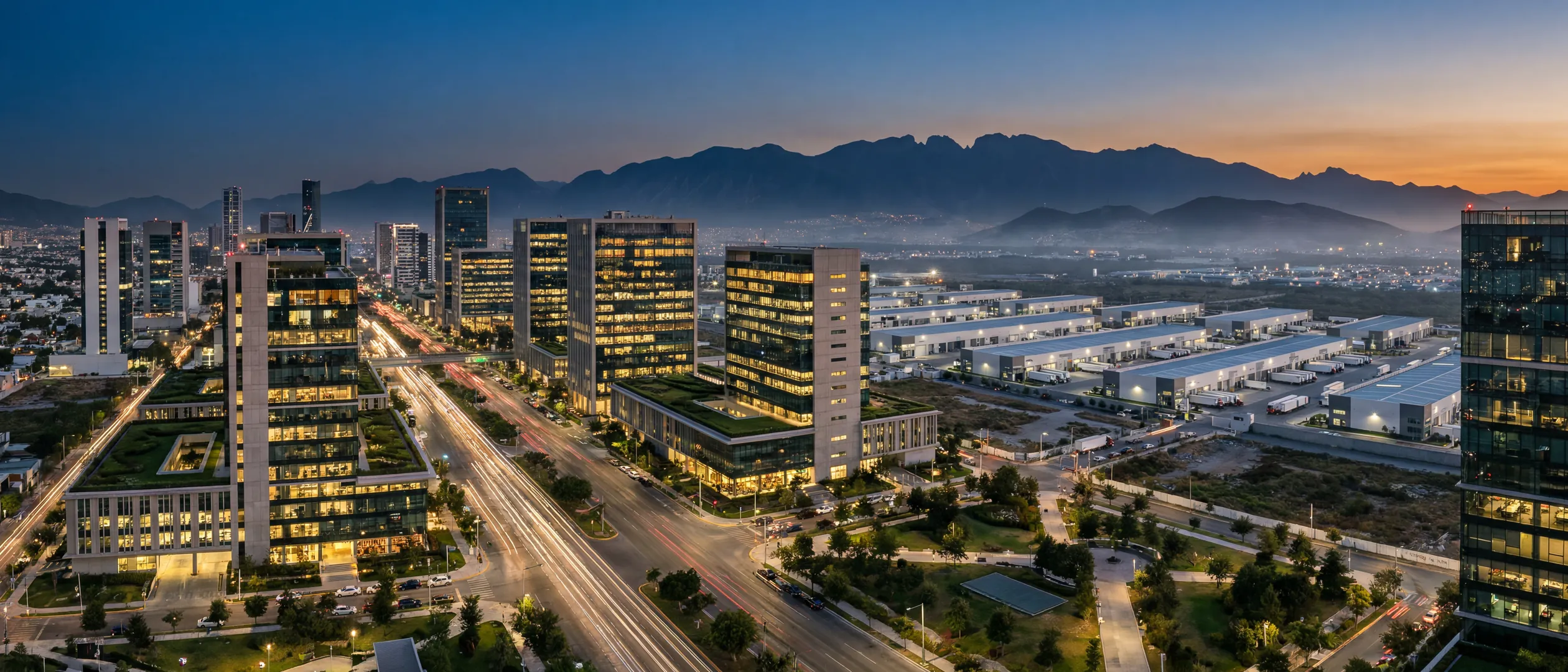 Corredor empresarial mexicano ao entardecer com torres de escrit&oacute;rios, parque industrial e avenidas iluminadas
